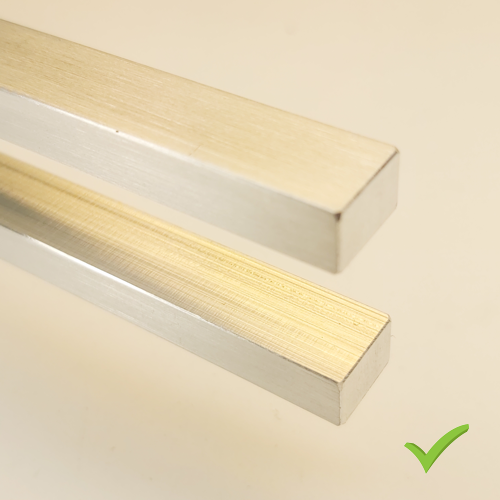 Two silver aluminum rails with brushed texture positioned diagonally, with a green approval checkmark in the bottom-right corner